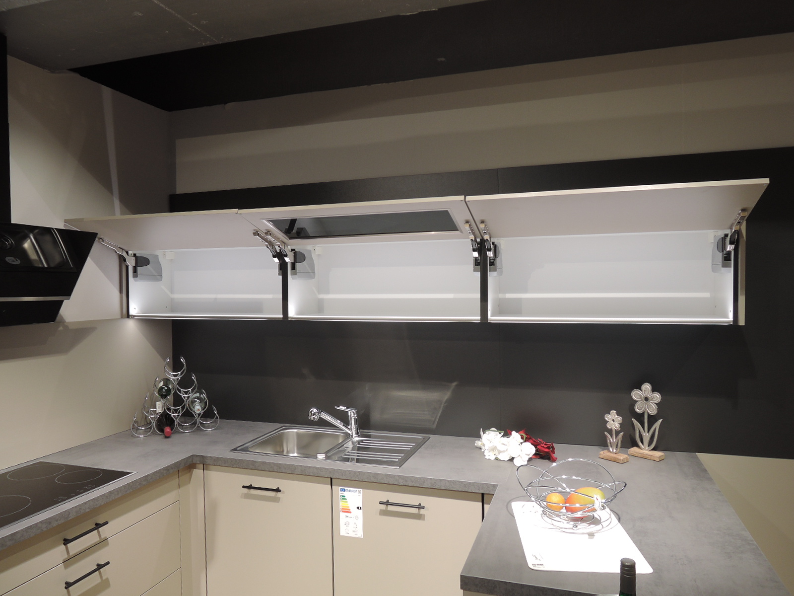 Blick auf die geöffneten Klappenschränke oberhalb der Spüle