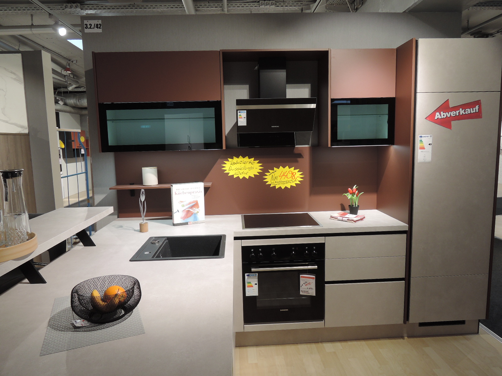 Blick in die Innenseite der Einbauküche auf Einbau-Herd, Kopffrei-Dunsthaube und Einbau-Kühlschrank