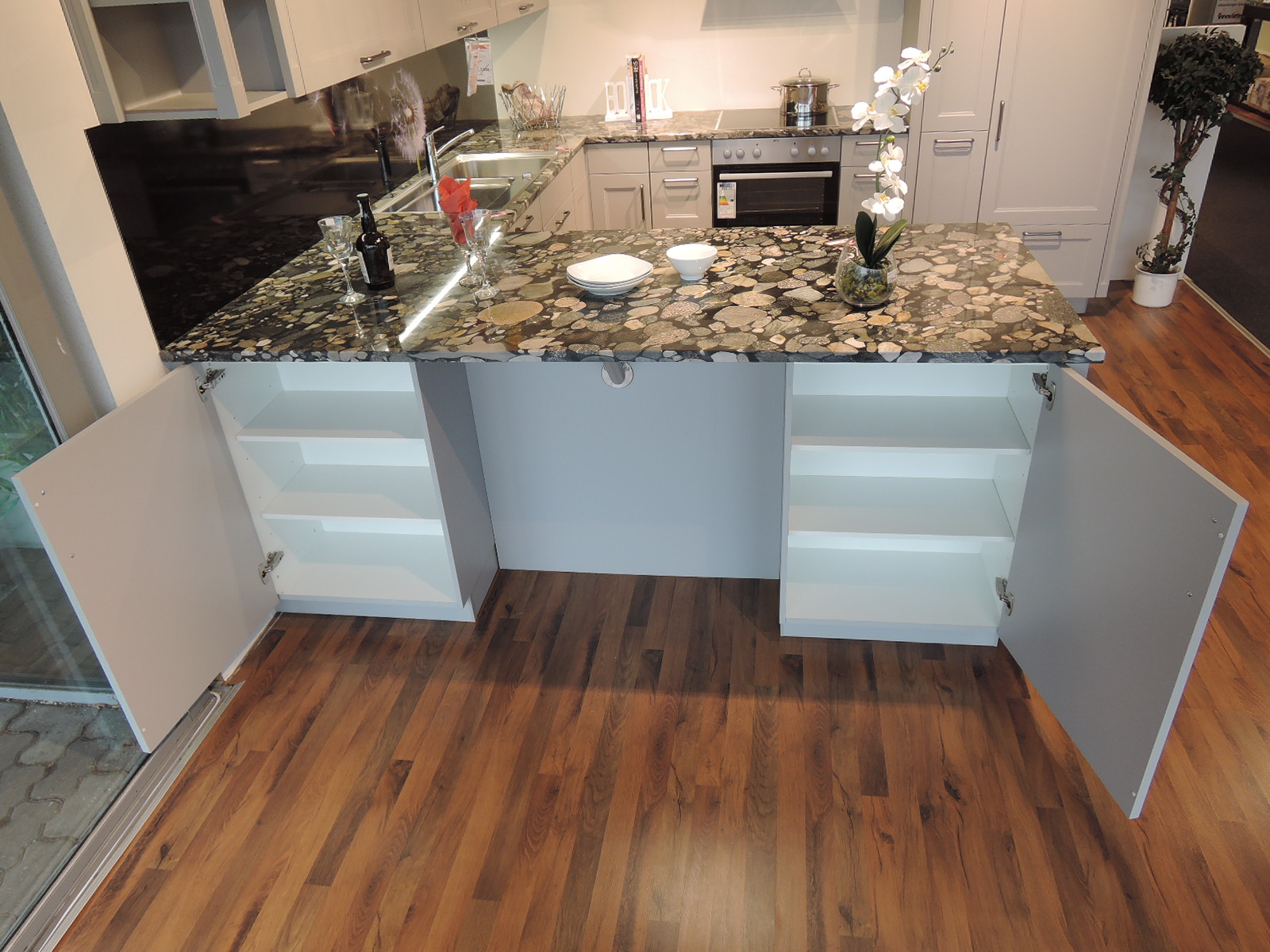 Blick auf die Außenseite der linken Seite der U-Küche mit geöffneten Unterschränken