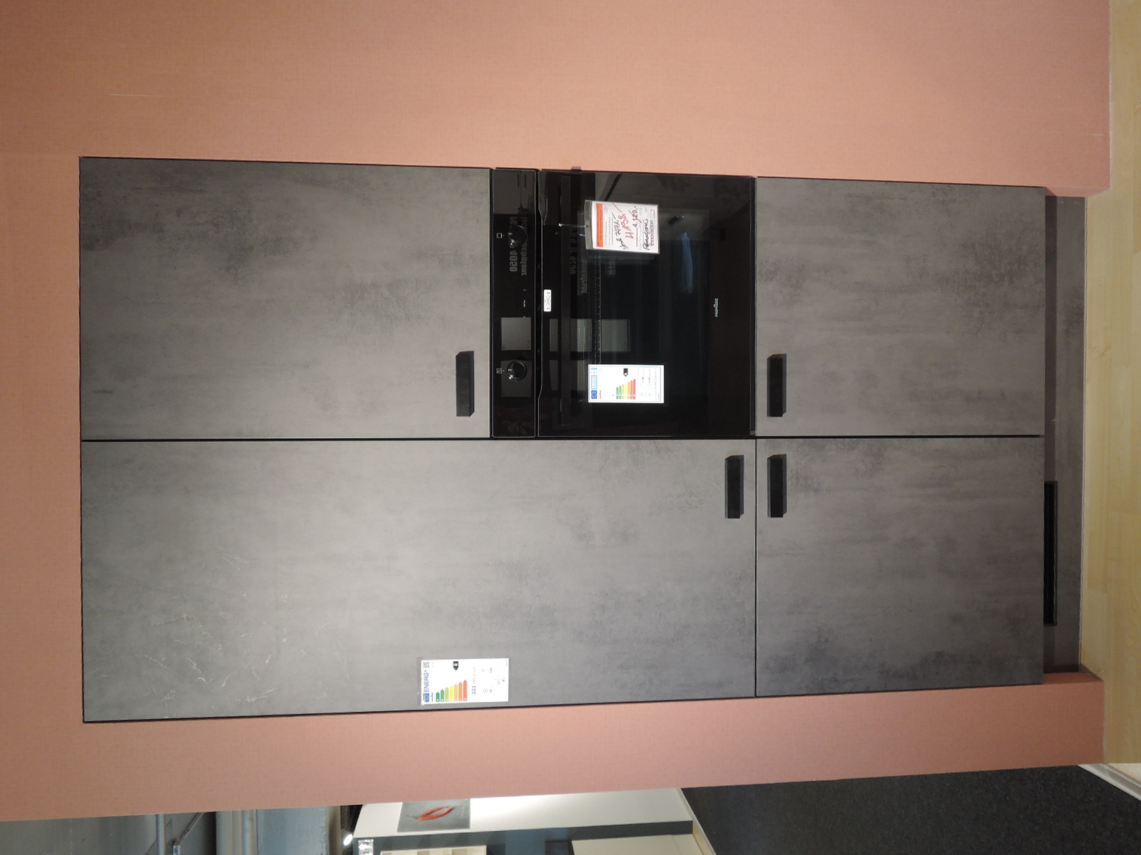 Blick auf die in die Wand eingelassene Einbaugeräteschränke mit Kühl-Gefrier-Kombi und Backofen  der Ausstellungsküche IP1200