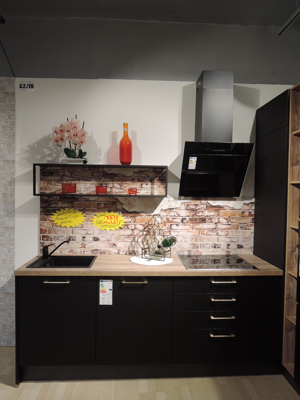 Blick auf die linke Seite der L-Ausstellungsküche 180811 mit Spüle, Induktionskochfeld, Kaminhaube