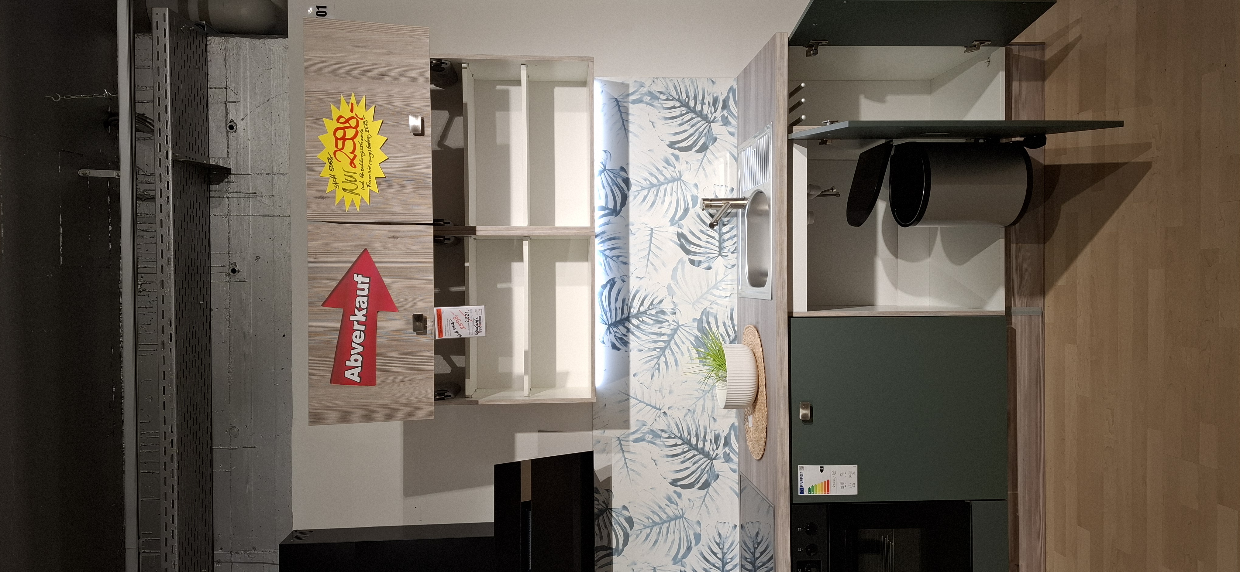 Blick in den geöffneten Spülenunterschrank mit Mülleimer und geöffneten Hängeschränken mit Faltlifttür