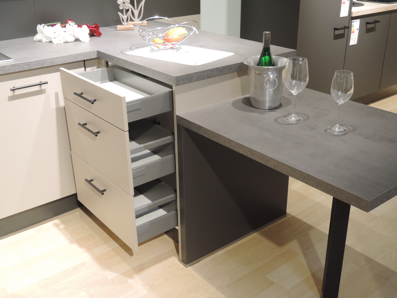 Blick auf die rechte Innenseite der U-Küche mit Tisch und geöffneten Auszügen