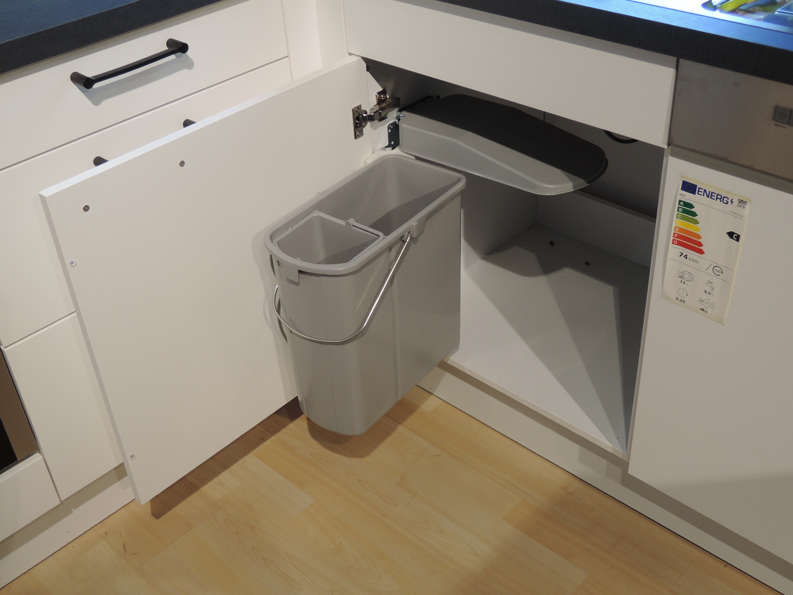 Ansicht in den geöffneten Spülenunterschrank mit schwenkbarem Müllsystem