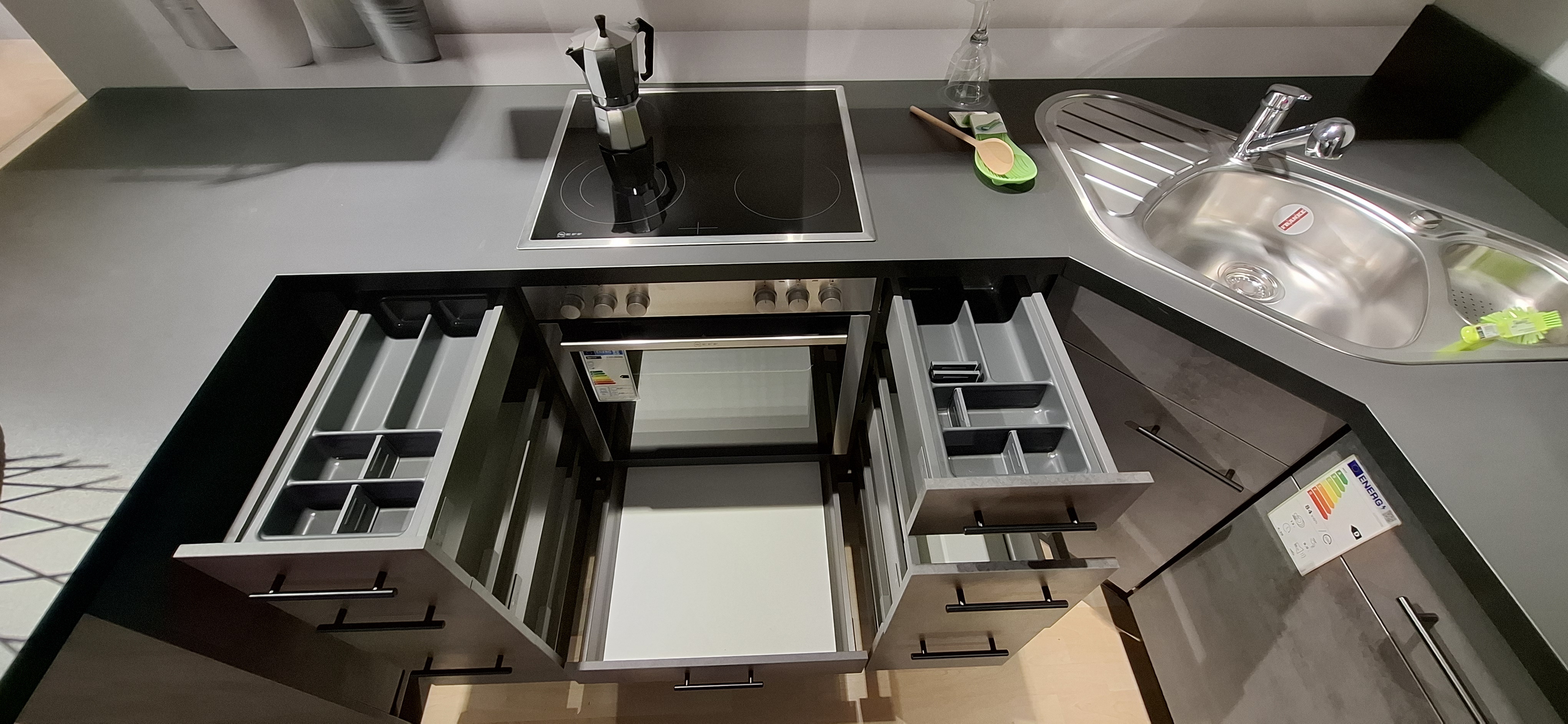 Einbauküche IP 1200 der Marke Impuls Weitere  Blick in die geöffneten Schubladen mit Besteckeinsatz, in die geöffnete Schublade unter dem Herd und auf das Glaskeramikkochfeld